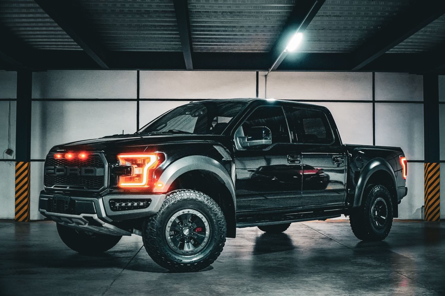 Black Ford F-150 pickup truck with tinted cab windows in a garage